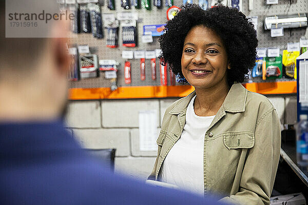 Eine afroamerikanische Eisenwarenverkäuferin bedient einen Kunden im Laden
