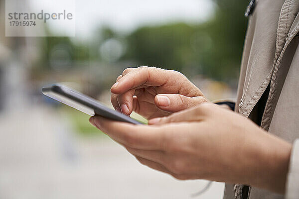 Nahaufnahme von Frauenhänden  die auf den Bildschirm eines Mobiltelefons tippen