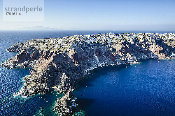 Luftaufnahme einer Insel im tiefblauen Meer der Ägäis  Felsformationen  weiß getünchte Häuser auf den Klippen.