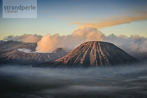Der Vulkan Mount Bromo  ein Soma-Vulkan und Teil des Tengger-Gebirges  dessen Kegel sich über den Nebel in der Landschaft erhebt.