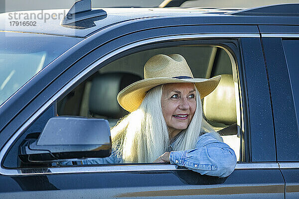 Ältere Frau im Auto mit Cowboyhut