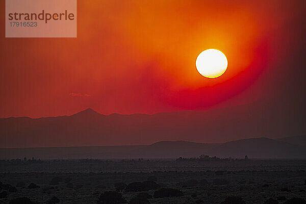 USA  New Mexico  Santa Fe  verheerender Rauch und untergehende Sonne über der Wüstenlandschaft