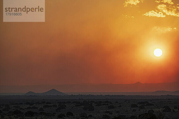 USA  New Mexico  Santa Fe  verheerender Rauch und untergehende Sonne über der Wüstenlandschaft