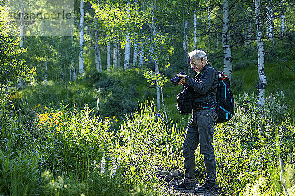Älterer Mann fotografiert beim Wandern