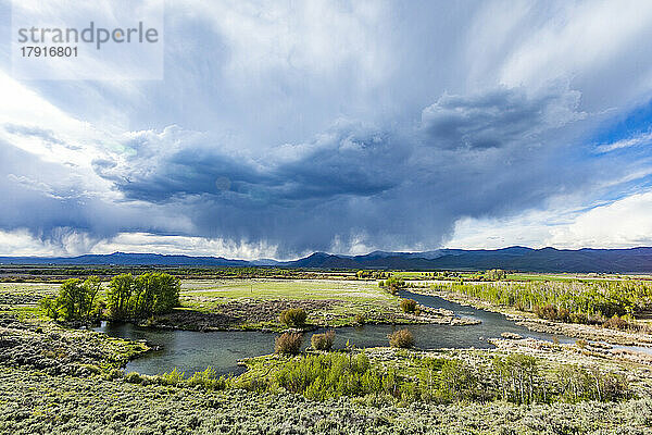 USA  Idaho  Bellevue  Sturmwolken über grünem Feld mit Bach