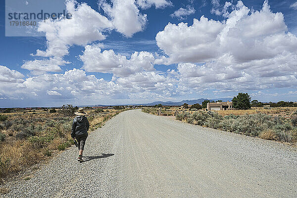USA  New Mexico  Santa Fe  Rückansicht einer Frau  die auf einer Landstraße geht