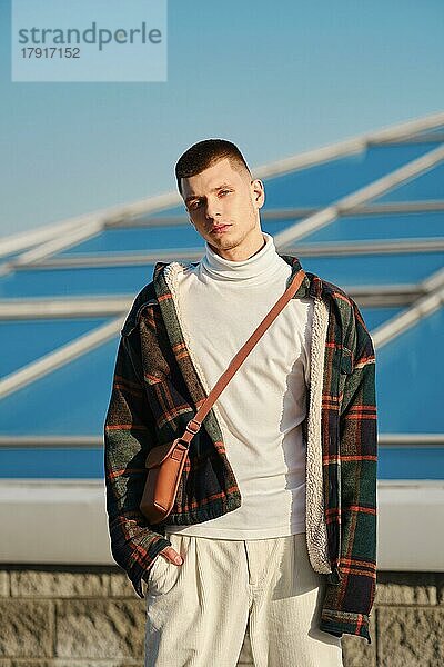 Urbane Mode. Junger Mann in lockerer Kleidung posiert auf der Straße