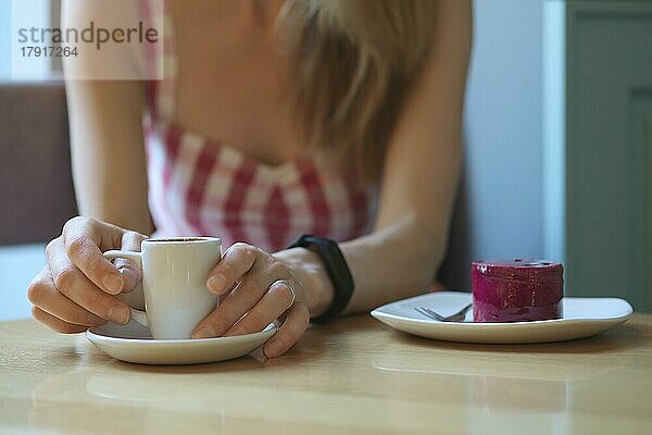 Hände eines Mädchens  das eine Tasse Kaffee hält