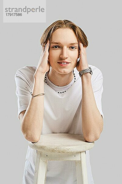 Closeup Porträt von positiven jungen Mann in weißem T-Shirt über grauem Hintergrund Studio