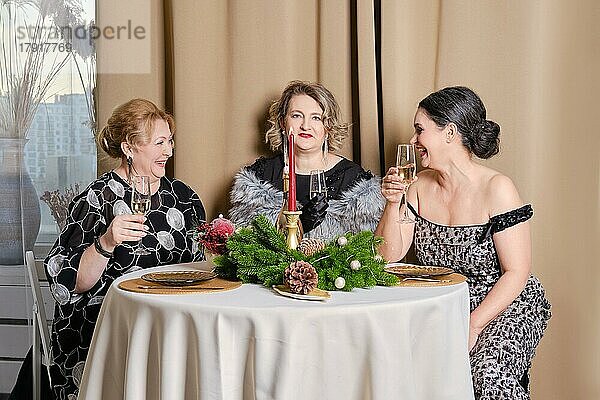 Drei fröhliche Frauen mittleren Alters  die Weihnachten feiern