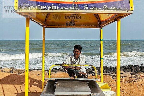 PONDICHERRY  INDIEN  2. FEBRUAR 2013: Nicht identifizierter indischer Straßen-Eisverkäufer mit Wagen am Strand