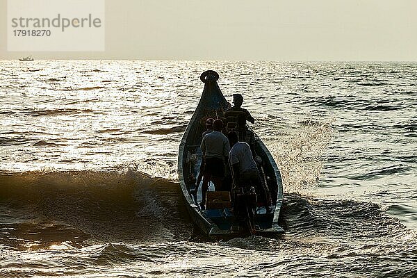 CHENNAI  INDIEN  10. FEBRUAR 2013: Gruppe von indischen Fischern  die bei Sonnenaufgang mit einem Boot zum Fischen ins Meer fahren