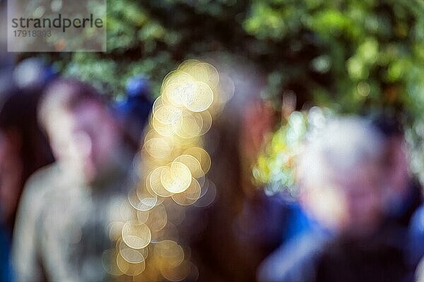 Bunte Menschenmenge in der Stadt  abstrakt  Sonnenlicht  goldene funkelnde Lichter  Bokeh  Symbolbild  Hintergrundbild