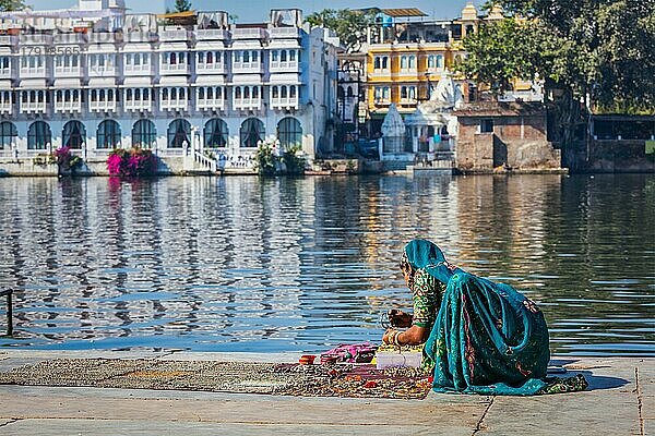 UDAIPUR  INDIEN  24. NOVEMBER 2012: Indische Frau in traditioneller Rajasthani-Kleidung verkauft Schmuck am Ghat des Pichola-Sees  Udaipur  Rajasthan  Indien  Asien