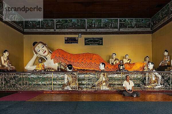 YANGON  MYANMAR  3. JANUAR 2014: Mann meditiert in der Nähe der Statue des liegenden Buddhas in der Shwedagon Paya Pagode