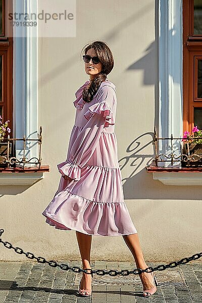 Outdoor städtischen Porträt der jungen schönen stilvollen Mädchen in übergroßen rosa Kleid