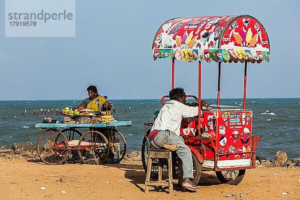 PONDICHERRY  INDIEN  2. FEBRUAR 2013: Nicht identifizierte indische Straßenverkäufer von Eiscreme und Snacks mit Rollwagen am Strand
