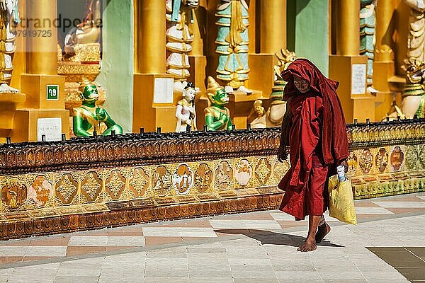 YANGON  MYANMAR  3. JANUAR 2014: Alter buddhistischer Mönch beim Spaziergang in der Shwedagon Paya Pagode  der heiligsten buddhistischen Pagode in Myanmar