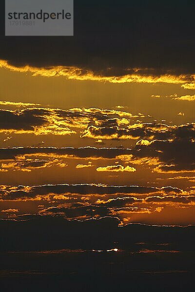 Afrikanische Wolken bei Sonnenuntergang in leuchtendem Orange und Rot. Namibia