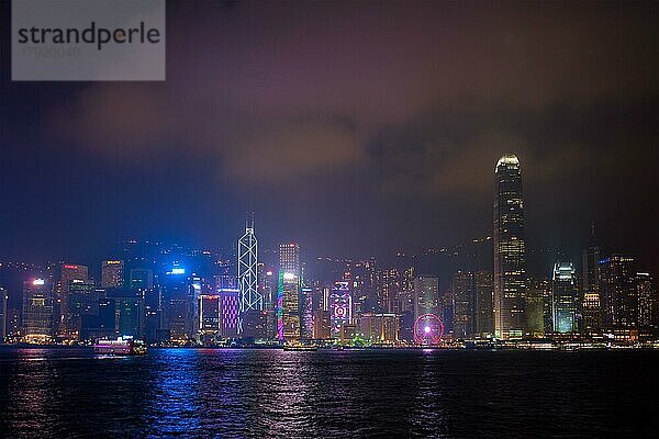 HONGKONG  CHINA  28. APRIL 2018: Hong Kong Skyline Stadtbild Downtown Wolkenkratzer über Victoria Harbour in den Abend beleuchtet mit Touristen Boot Fähren  Hong Kong  China  Asien