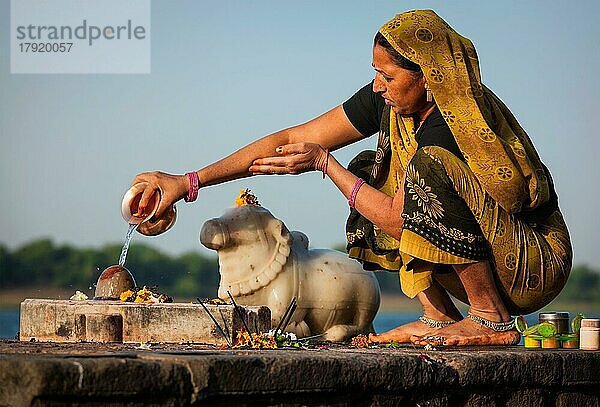 MAHESHWAR  INDIEN  26. APRIL: Eine Inderin führt am 26. April 2011 in Maheshwar  Madhya Pradesh  Indien  eine morgendliche Pooja am heiligen Fluss Narmada durch. Für Hindus ist der Narmada einer der 5 heiligen Flüsse Indiens  Asien