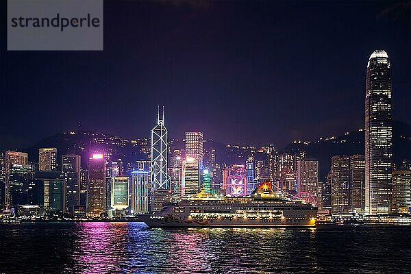 HONGKONG  CHINA  1. MAI 2018: Hongkong Skyline Stadtbild Downtown Wolkenkratzer über Victoria Harbour in den Abend mit Kreuzfahrtschiff beleuchtet. Hongkong  China  Asien