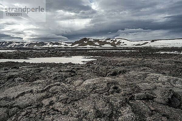 Versteinerte Lava  Lavafelder und schneebedeckte Vulkanlandschaft  Krater des Vulkans Askja  isländisches Hochland  Island  Europa