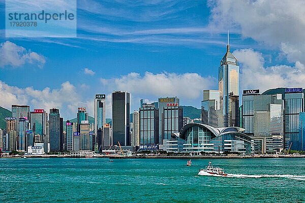 HONGKONG  CHINA  1. MAI 2018: Boot im Victoria Harbour und Hongkong Skyline Stadtbild Downtown Wolkenkratzer über in der Tageszeit mit Wolken. Hongkong  China. Horizontaler Kameraschwenk