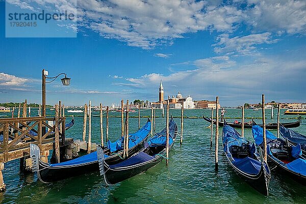 VENEDIG  ITALIEN  27. JUNI 2018: Gondeln und Gondoliere in der Lagune von Venedig am Markusplatz (San Marco) mit der Kirche San Giorgio di Maggiore im Hintergrund in Venedig  Italien  Europa