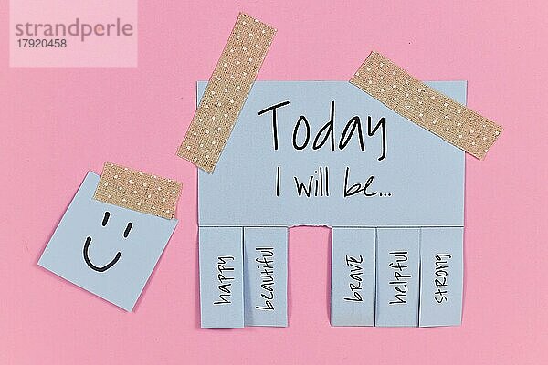 Motivationskonzept mit blauem Abreißzettel mit Text Heute werde ich sein. . und Worte glücklich  schön  mutig  hilfreich und stark auf rosa Hintergrund