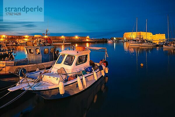 Venezianische Festung in Heraklion und vertäute griechische Fischerboote im Hafen  Insel Kreta  Griechenland in der Dämmerung