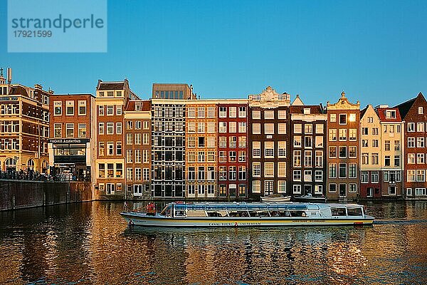 AMSTERDAM  NIEDERLANDE  20. MAI 2018: Grachtenkreuzfahrt Touristenboot in Amsterdam am Damrak Kanal und Pier. Amsterdam  die Hauptstadt der Niederlande  hat mehr als hundert Kilometer Grachten
