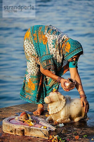 MAHESHWAR  INDIEN  26. APRIL: Eine Inderin führt am 26. April 2011 in Maheshwar  Madhya Pradesh  Indien  eine morgendliche Pooja am heiligen Fluss Narmada durch. Für Hindus ist der Narmada einer der 5 heiligen Flüsse Indiens  Asien