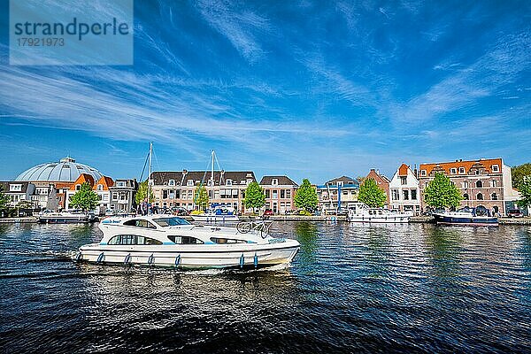 HAARLEM  NIEDERLANDE  6. MAI 2017: Boote und Häuser auf dem Fluss Spaarne mit blauem Himmel. Haarlem  Niederlande  Europa