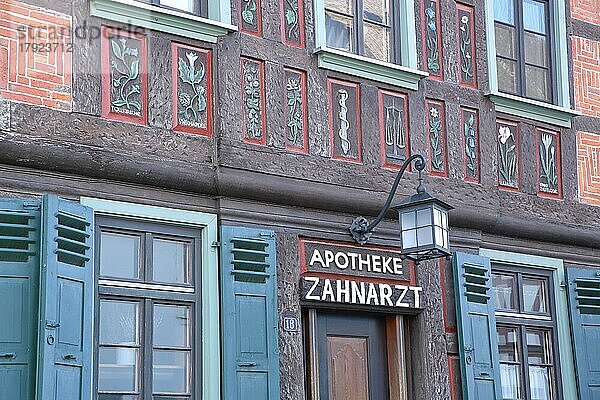 Historisches Fachwerkhaus mit Blumen als Wandgemälde und Holzschnitzerei mit Inschrift Apotheke und Zahnarzt  Babenhausen  Hessen  Deutschland  Europa