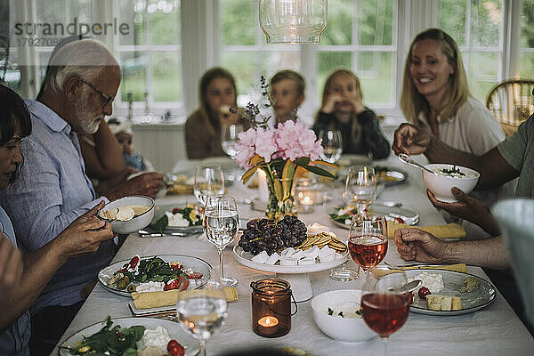 Mehrgenerationen-Familie genießt das Abendessen auf dem Tisch während einer Party zu Hause
