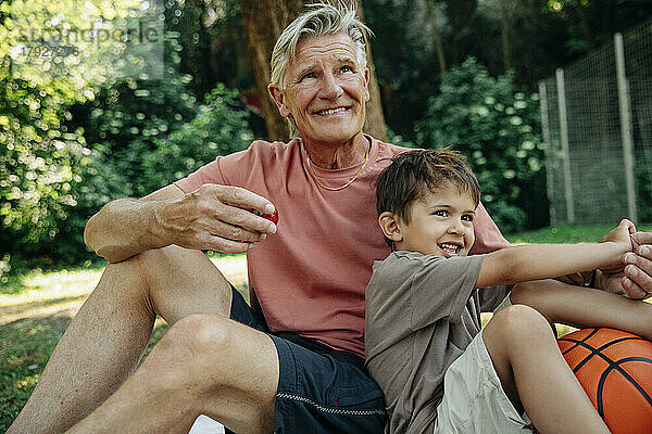 Glücklicher Junge genießt mit Großvater beim Picknick im Park