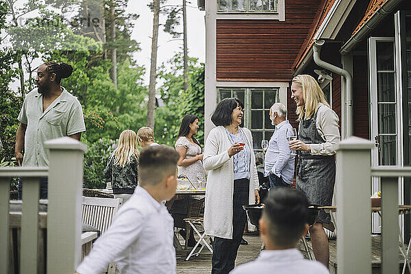 Frauen  die sich bei einer Dinnerparty mit einem Weinglas in der Hand unterhalten