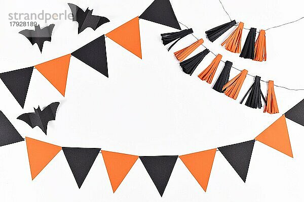 Halloween-Hintergrund mit Girlanden und Papier Fledermäuse in traditionellen Farben orange und schwarz auf weißem Hintergrund mit Kopie Raum