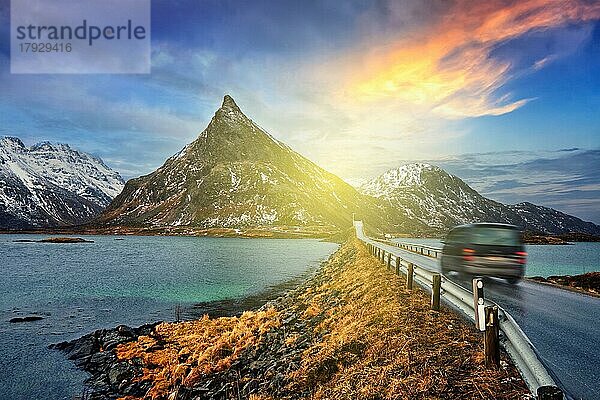 Auto auf Straße in norwegischem Fjord bei Sonnenuntergang. Lofoten-Inseln  Norwegen. Mit Bewegungsunschärfe