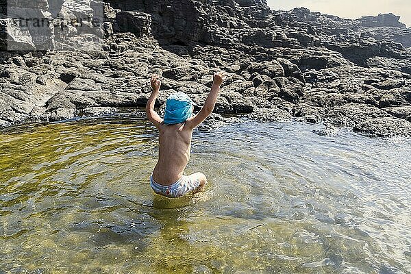 Kleiner Junge springt fröhlich in den natürlichen Pools von Charcones auf Lanzarote  Kanarische Inseln  Spanien  Europa