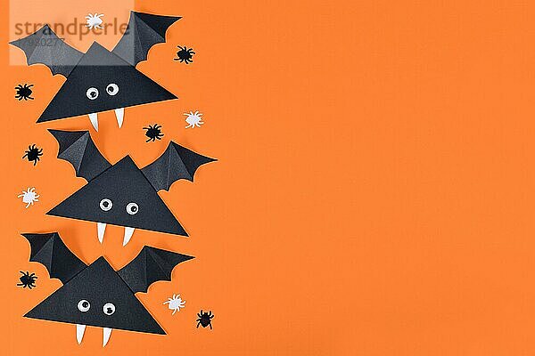 Nettes Papier Vampirfledermäuse mit lustigen Kulleraugen auf der Seite der orangefarbenen Halloween-Hintergrund mit leeren Kopie Raum