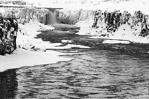 Wasserfall Selfoss mit dem Fluss Jökullsa a Fjöllum  vereiste und schneebedeckte Felswände und Uferstreifen  Schwarzweissaufnahme  Nordurland Eyestra  Island  Europa
