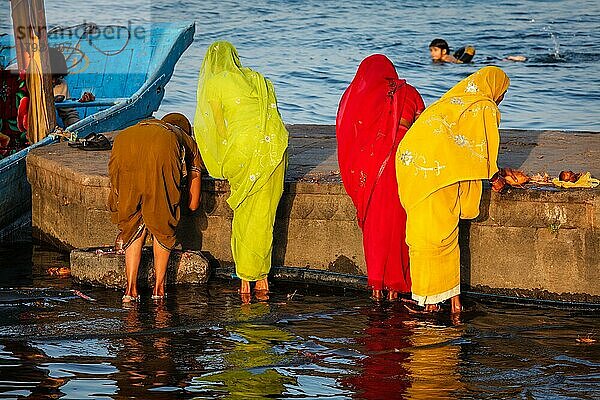 Indische Frauen bei der morgendlichen Pooja an den Ghats des heiligen Flusses Narmada. Maheshwar  Madhya Pradesh  Indien  Asien