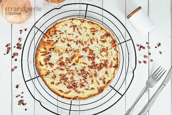 Draufsicht auf eine pizzaähnliche Speise namens Flammkuchen aus dem deutsch-französischen Grenzgebiet im Elsass