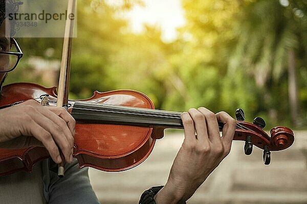 Nahaufnahme der Hände beim Geigenspiel im Freien. Violinist Künstler spielt eine Melodie im Freien  Porträt von Mann spielt Geige bei Sonnenuntergang. Bild von einer Person  die im Freien Geige spielt