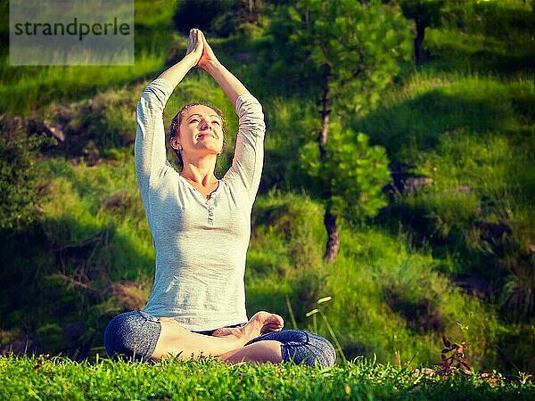 Meditation und Entspannung Yoga im Freien  junge Frau meditiert und entspannt in Padmasana Lotus Pose) auf grünem Gras im Wald. Vintage Retro-Effekt gefiltert Hipster-Stil Bild