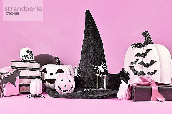 Rosa Halloween-Deko mit schwarzen und weißen Kürbissen  Hexenhut  Zauberbüchern  Geschenken und Spinnen