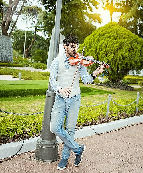 Porträt eines Geige spielenden Mannes auf der Straße. Jacke Künstler spielt Geige im Freien  Bild von einer Person spielt Geige im Freien. Mann spielt Geige auf der Straße