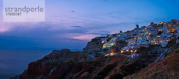 Panorama der berühmten griechischen ikonischen malerischen Reiseziel Oia Dorf mit traditionellen weißen Häusern und Windmühlen in Santorini Insel in den Abend blaue Stunde  Griechenland  Europa